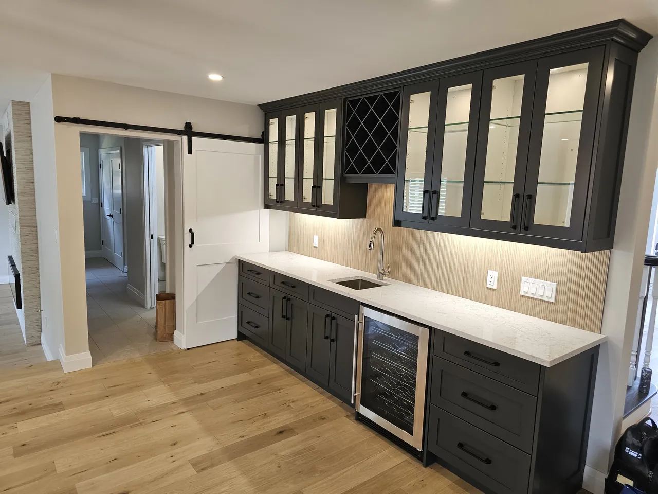 Dark shaker bar cabinets with glass uppers, a wine rack and a beverage fridge