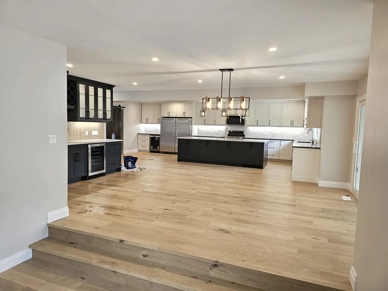 Open concept kitchen and bar seen from a step down family room