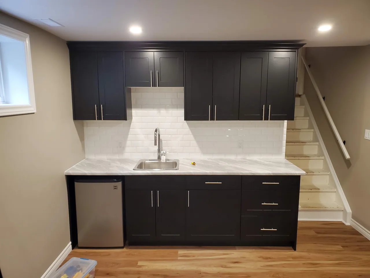Basement kitchenette with espresso shaker cabinets and a subway tile backsplash