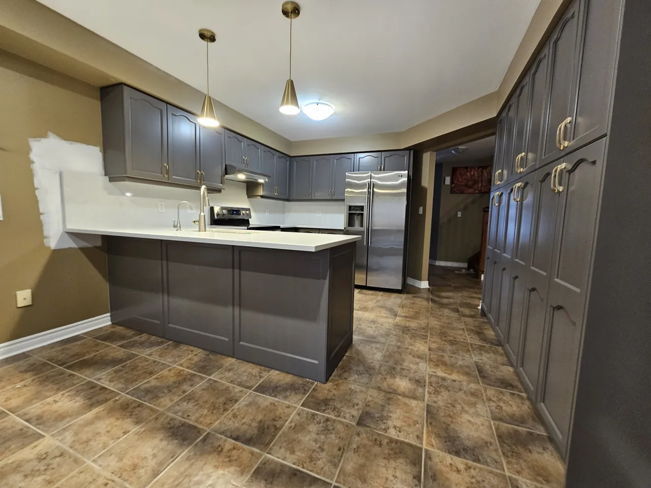 Kitchen cabinets resprayed in charcoal grey with brass hardware