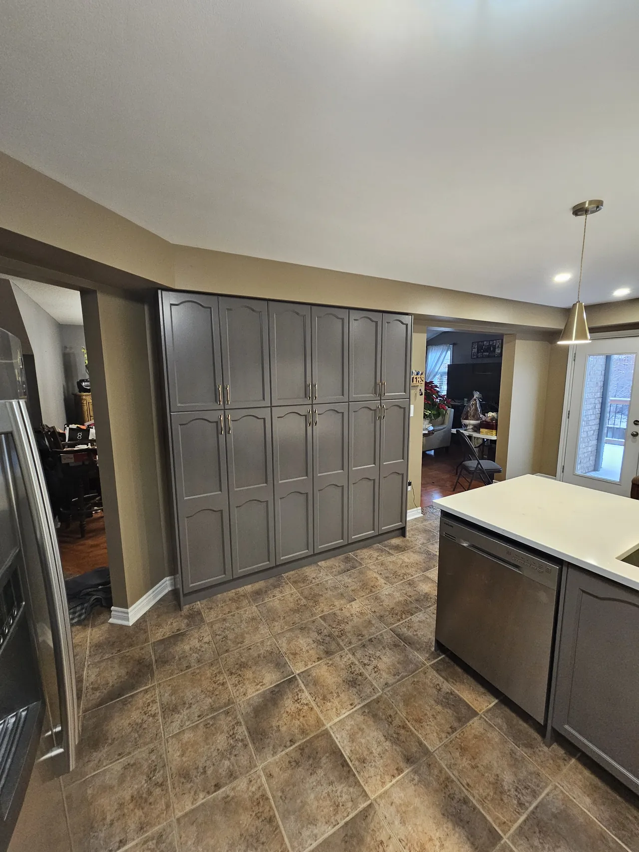 Full height pantry cabinets resprayed in charcoal with brass pulls